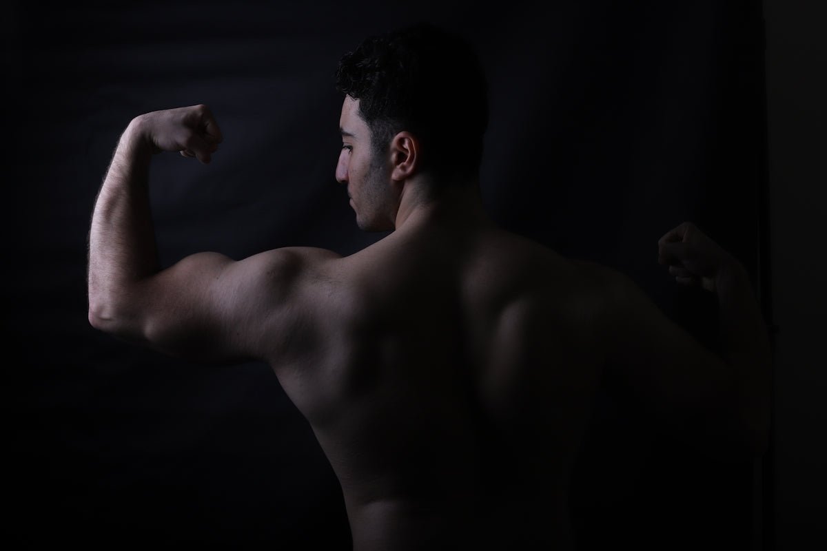 A bodybuilder flexes his biceps for the camera.